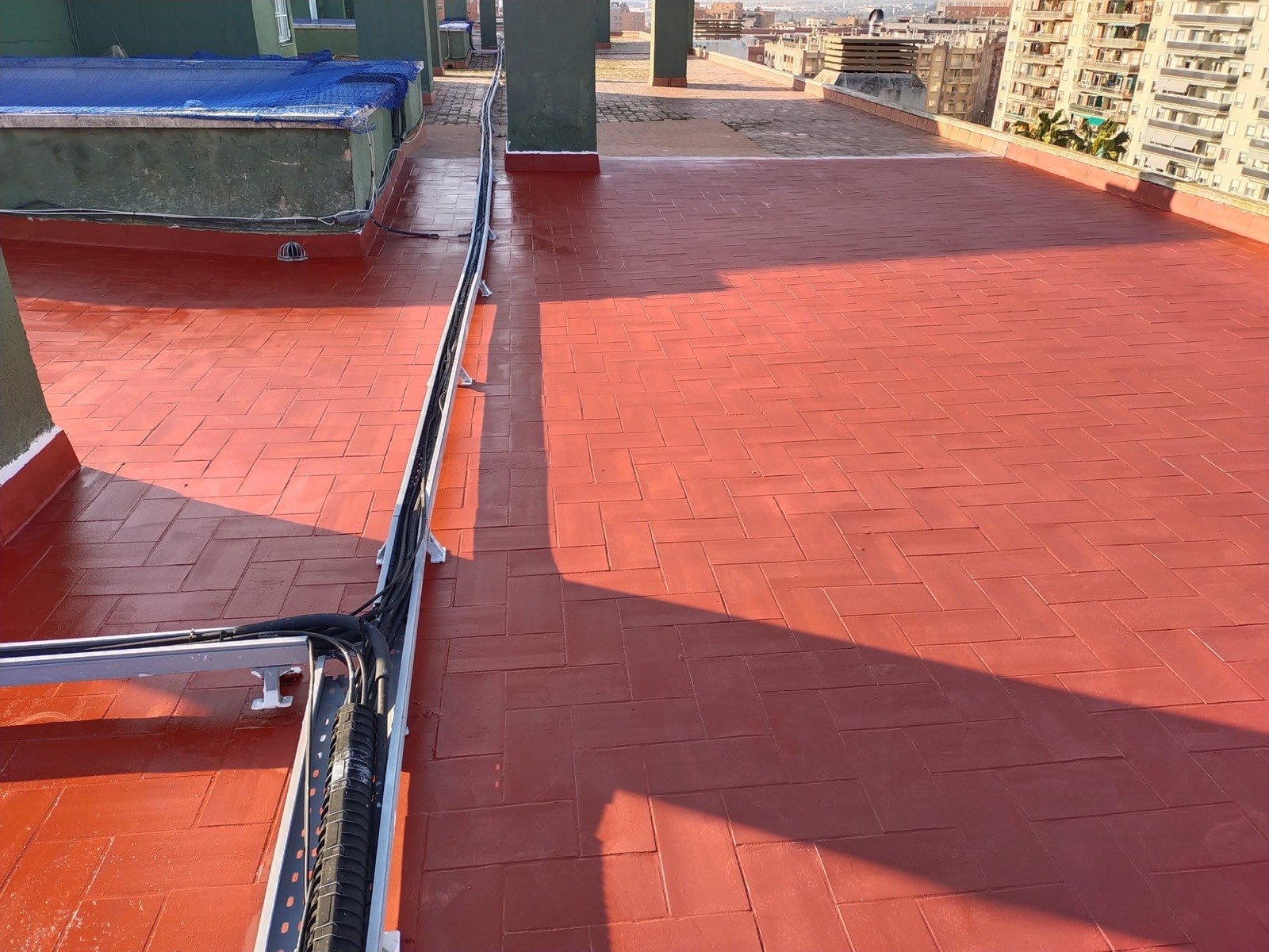 Terrassa de terrat reformada amb paviment ceràmic vermell i canalització de cables